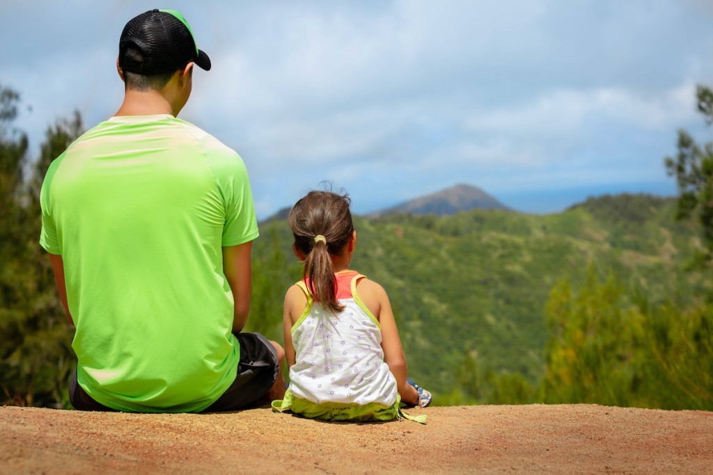 Father And Little Kid Sitting Together In Nature.