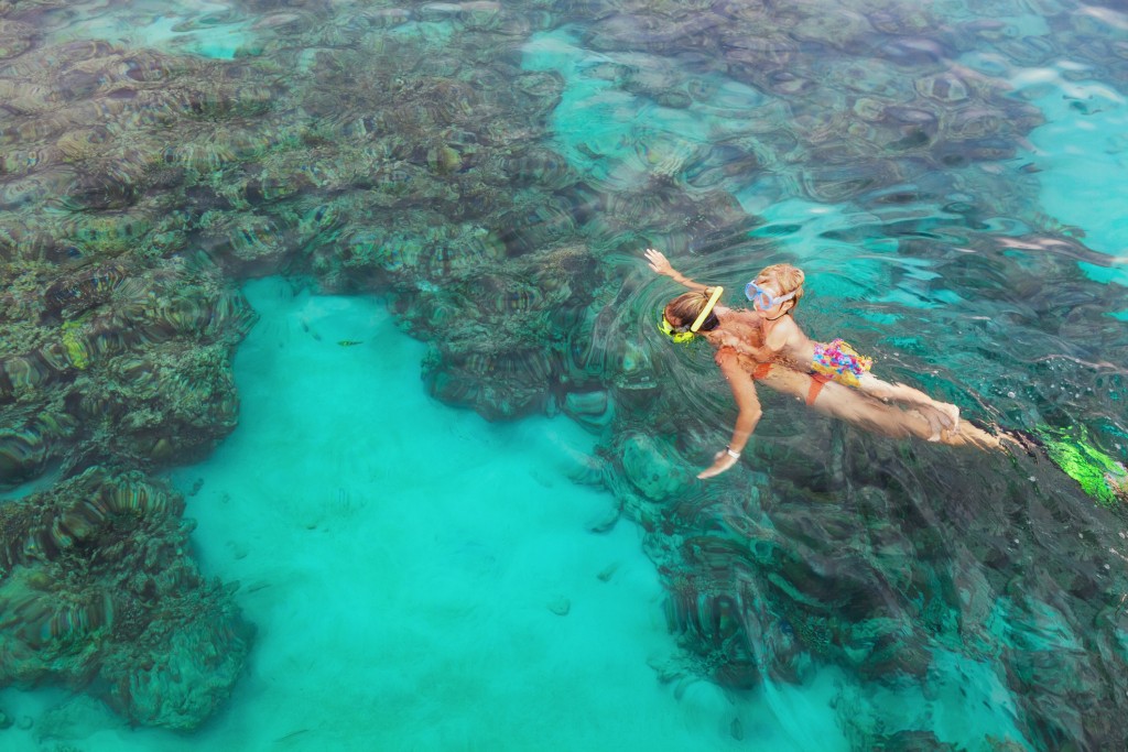 Mother, Kid In Snorkeling Mask Dive Underwater With Tropical Fishes
