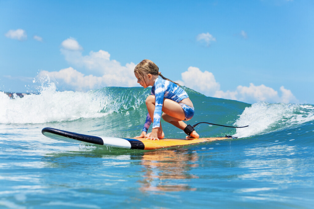 Young Surfer Rides On Surfboard With Fun On Sea Waves
