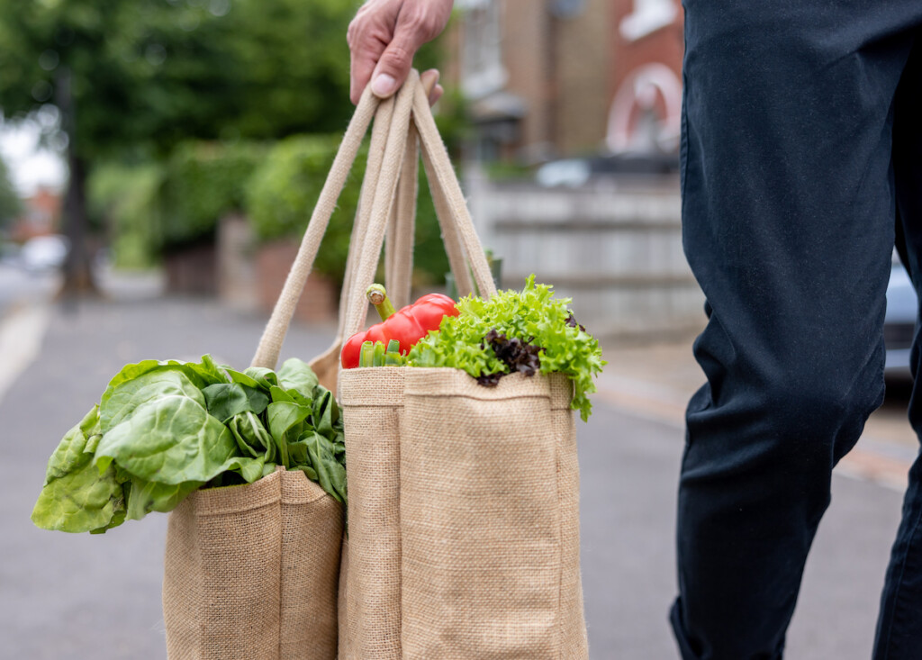 Close Up On A Man Carrying A Shopping Bag With Groceries On His Way Home