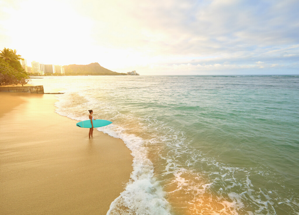 Pacific Islander Woman Holding Surfboard On Beach