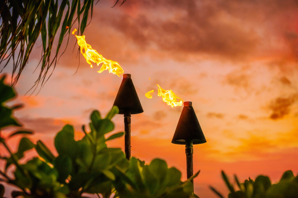 Hawaii Luau Party Maui Fire Tiki Torches With Open Flames Burning At Sunset Sky Clouds At Night. Hawaiian Cultural Travel Vacation Background.